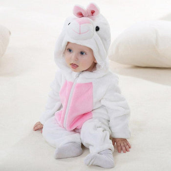 Jeune enfant assis qui porte un pyjama lapin blanc et rose