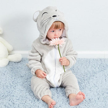 Enfant qui sent une fleur et qui porte un pyjama gris souris